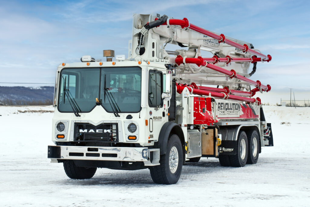 Front view of one of Revolution Rock Products' trucks, a white and red concrete pumping truck with a large white boom arm with red piping.